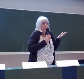 An image of a woman holding a mic and talking 