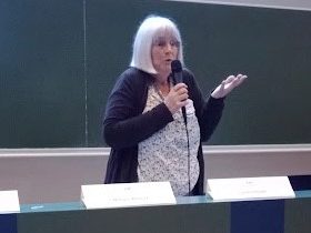 An image of a woman holding a mic and talking