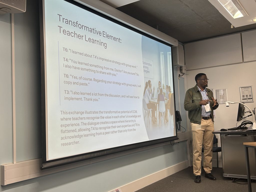 A man standing in front of the projected screen, with the title - Transformative Element: Teacher Learning, followed by quotes from teachers, and some explanatory text. 